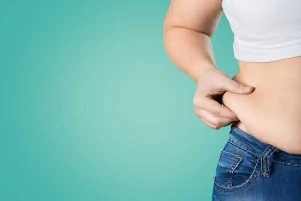 Image of woman pinching her love handles to show weight gain Brentwood